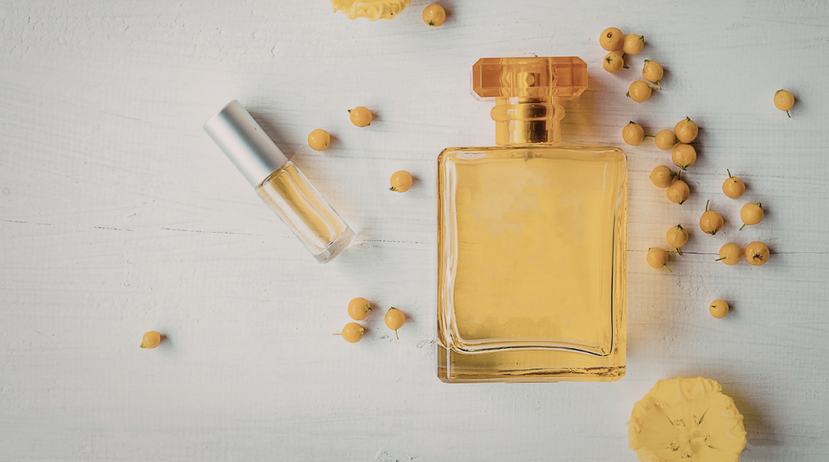 Frasco de perfume com elementos naturais ao redor representando ingredientes que podem causar alergia
